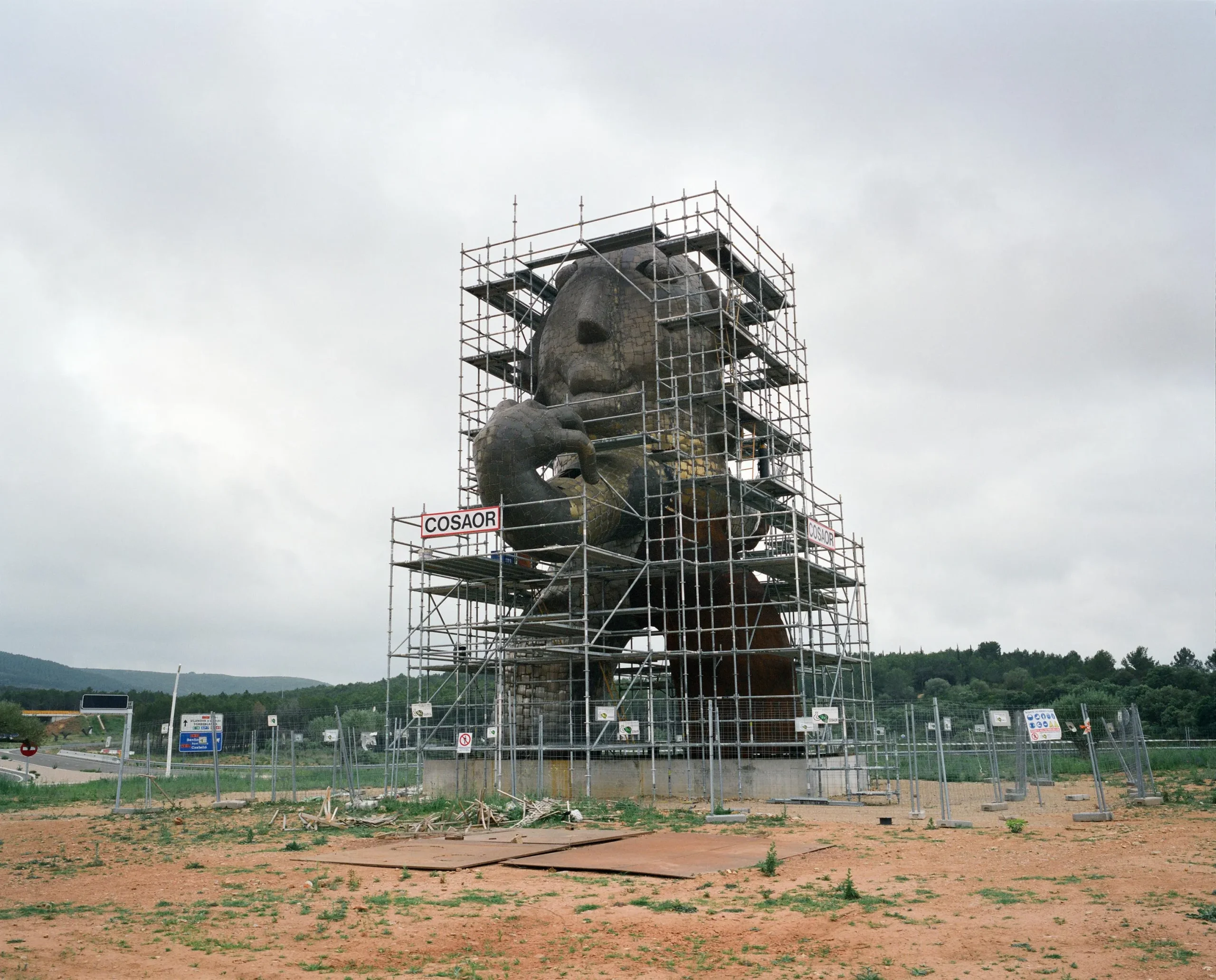 Monumento gigante de piedra con forma de cabeza humana rodeado de andamios en un descampado, parte del proyecto La idea de éxito de Markel Redondo.